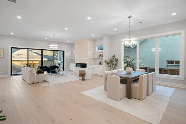 a view of a dining room and livingroom with furniture wooden floor a chandelier
