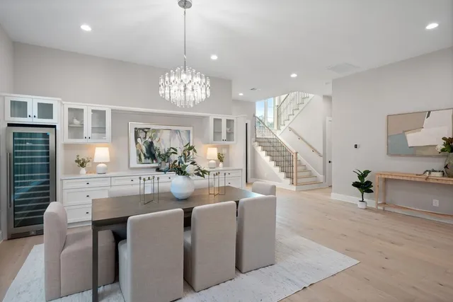 a living room with furniture kitchen view and a large window