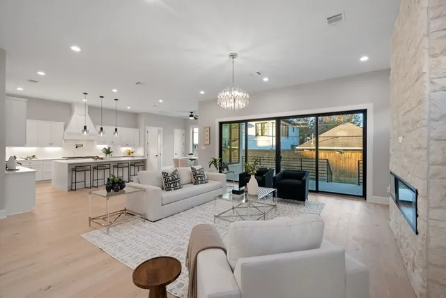 a kitchen with kitchen island granite countertop a sink a stove a refrigerator and white cabinets