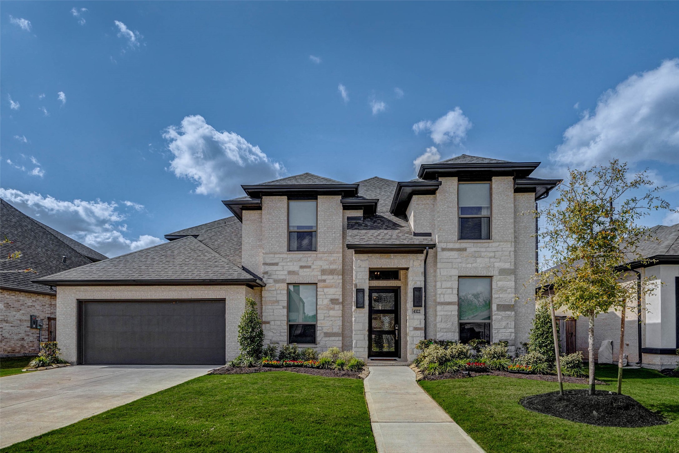 4322 Southpoint Way Fulshear, TX 77441 - Photo 2 of 50 a front view of a house with a garden and plants
