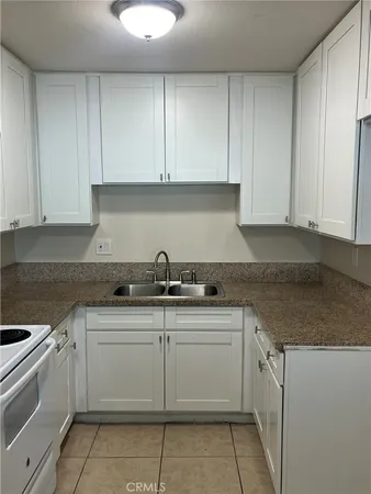 a kitchen with stainless steel appliances granite countertop a sink and dishwasher with white cabinets