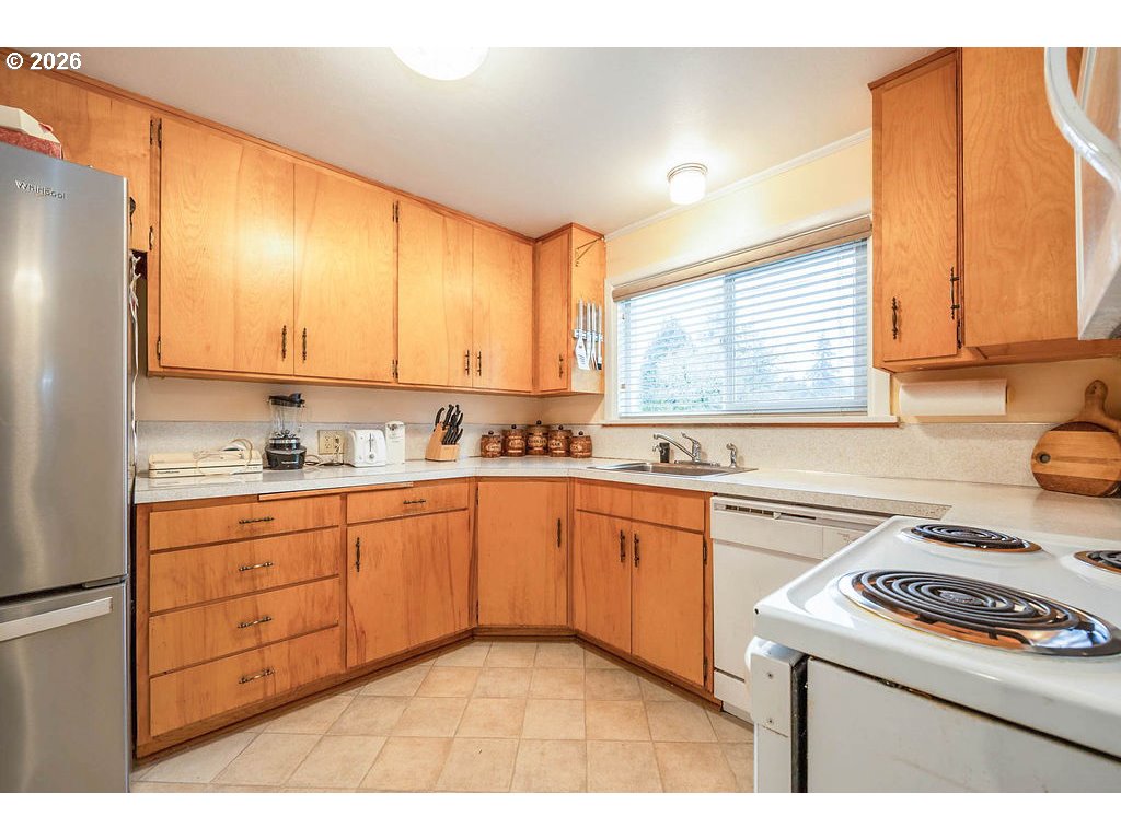 190 Hunsaker Lane Eugene, OR 97404 - Photo 15 of 28 a kitchen with granite countertop wooden cabinets stove top oven and sink