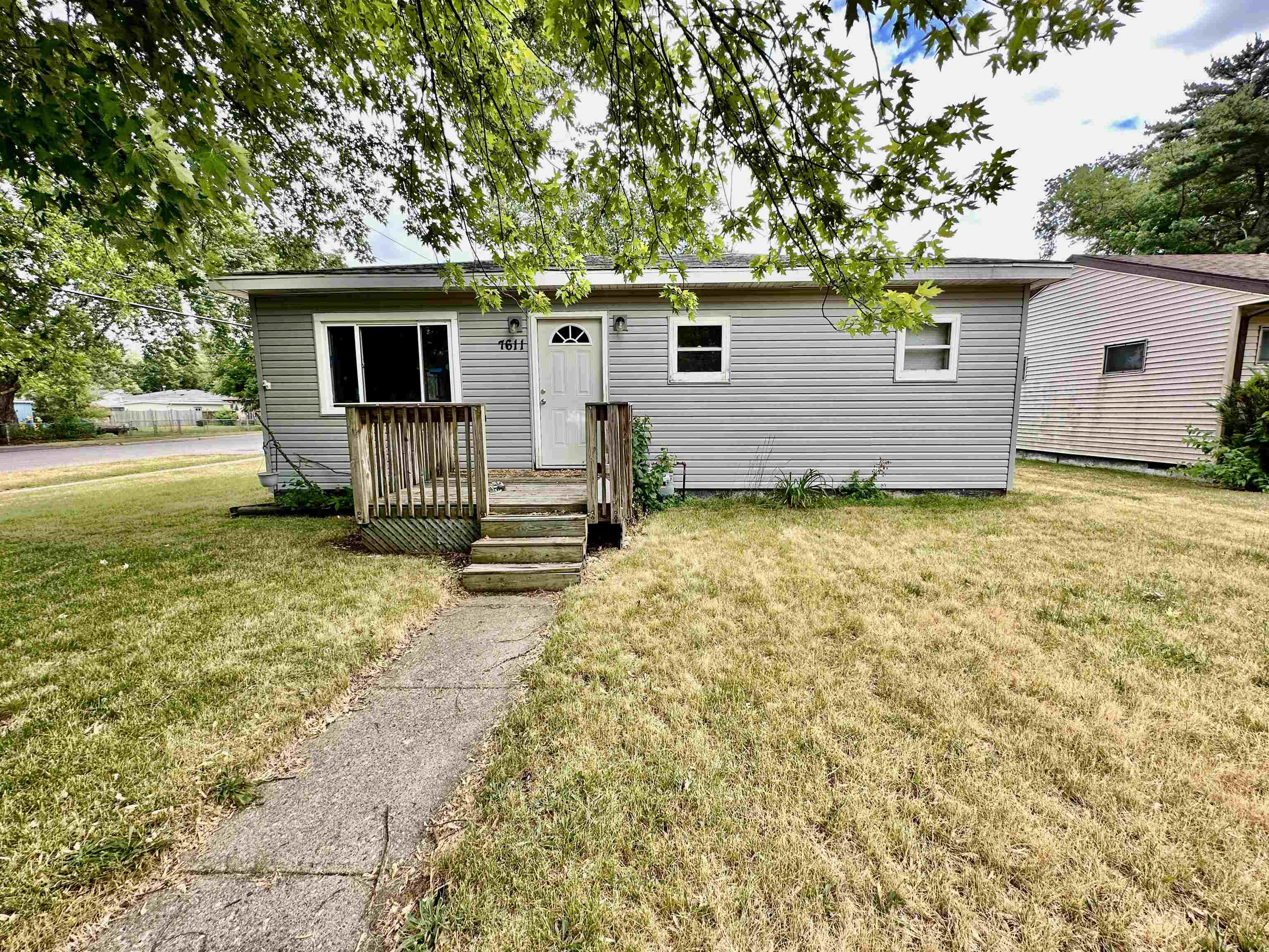 a view of a house with backyard and a tree