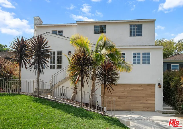 a front view of house with yard and potted plants