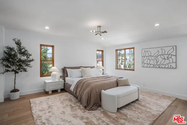 a spacious bedroom with a bed and a chandelier
