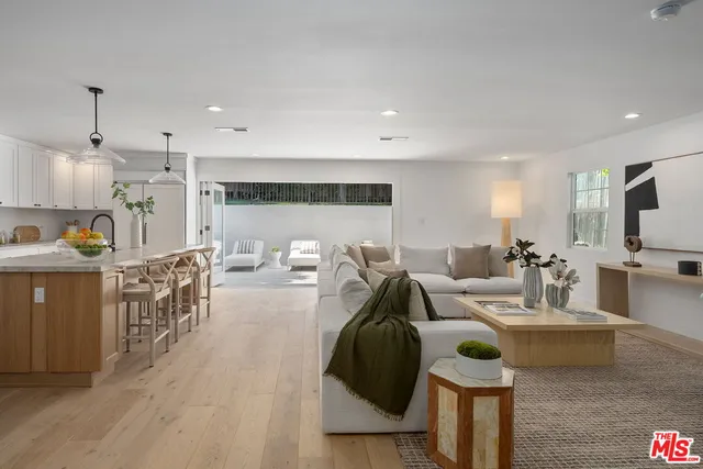 a kitchen with a dining table chairs and white cabinets
