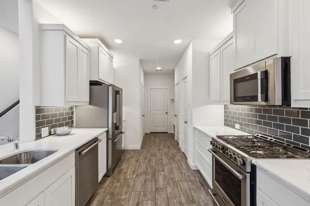 a kitchen with stainless steel appliances a stove sink microwave and cabinets