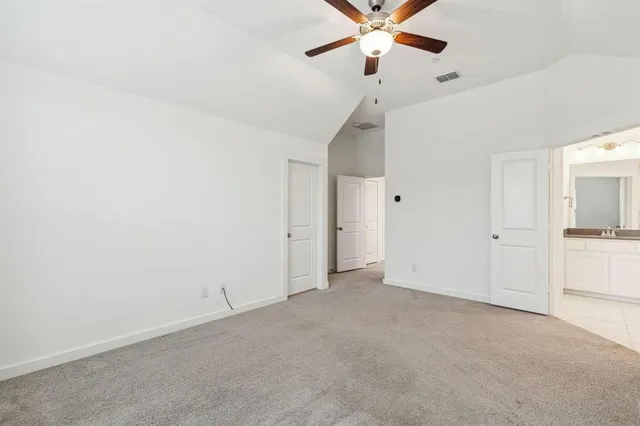 a bed sitting in a bedroom next to a bathroom