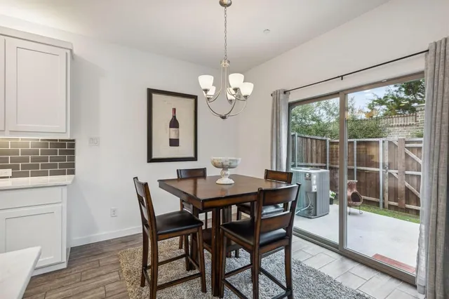 a dining room with furniture a chandelier and wooden floor