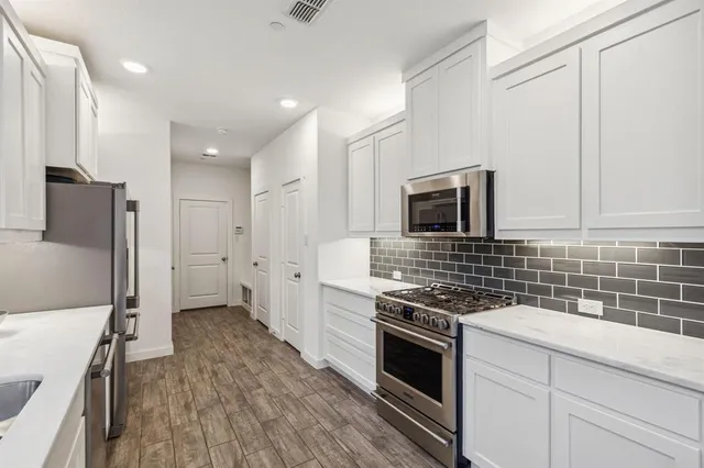 a kitchen with stainless steel appliances a stove a sink and a refrigerator