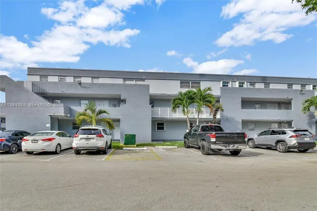 a front view of a house with a yard and potted plants
