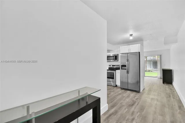 a kitchen with cabinets and wooden floor