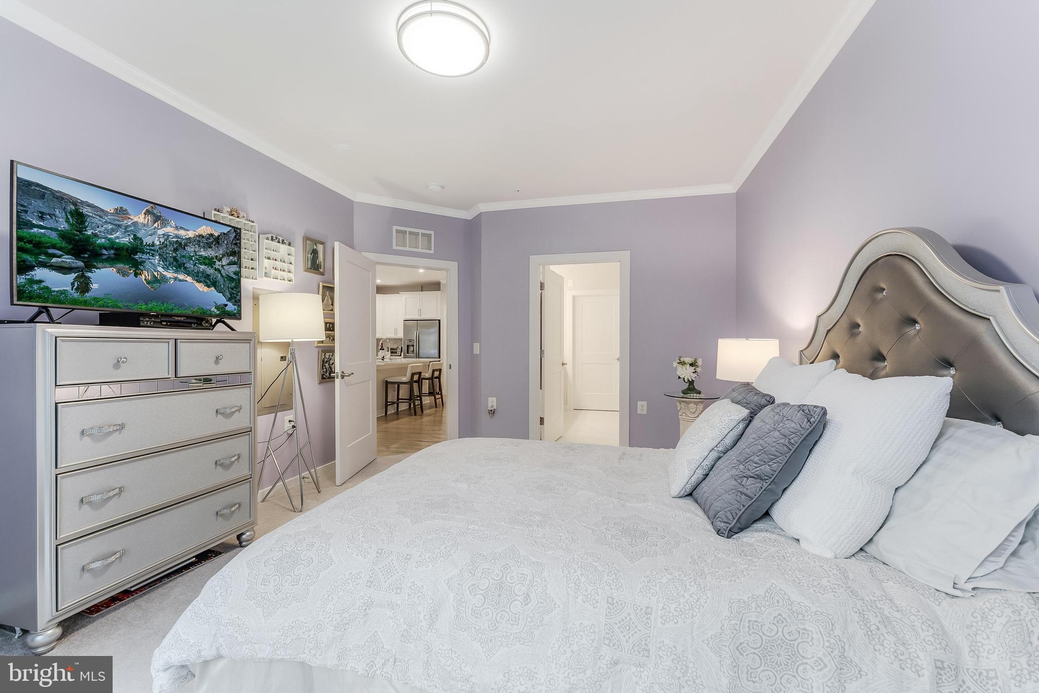 1675 Bandit Loop, Unit 105B Reston, VA 20190 - Photo 21 of 27 a bedroom with a bed and a flat screen tv