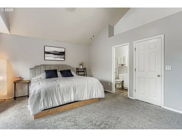 a bedroom with a bed and a painting on the wall