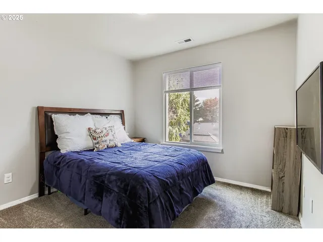 a bedroom with a bed window and a table