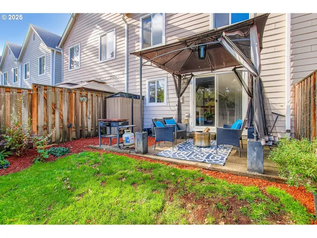 a view of a chair and table in backyard of the house