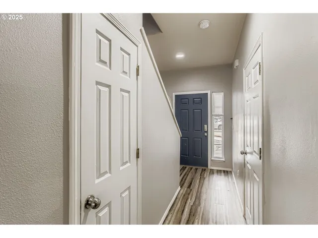 a view of a hallway with wooden floor and staircase