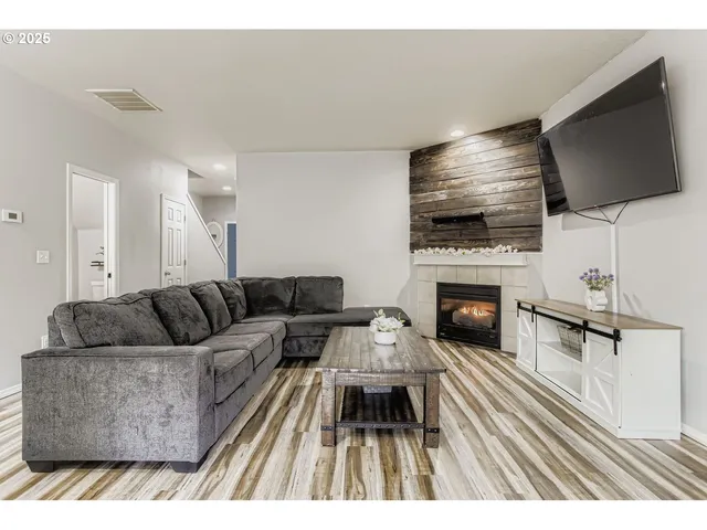 a living room with furniture a flat screen tv and a fireplace