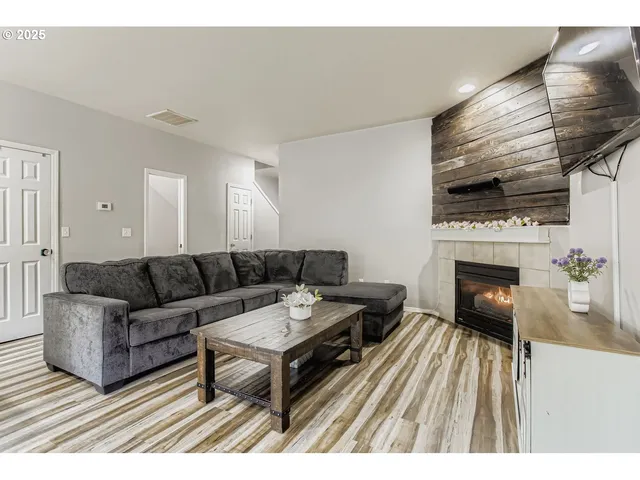 a living room with furniture a flat screen tv and a fireplace