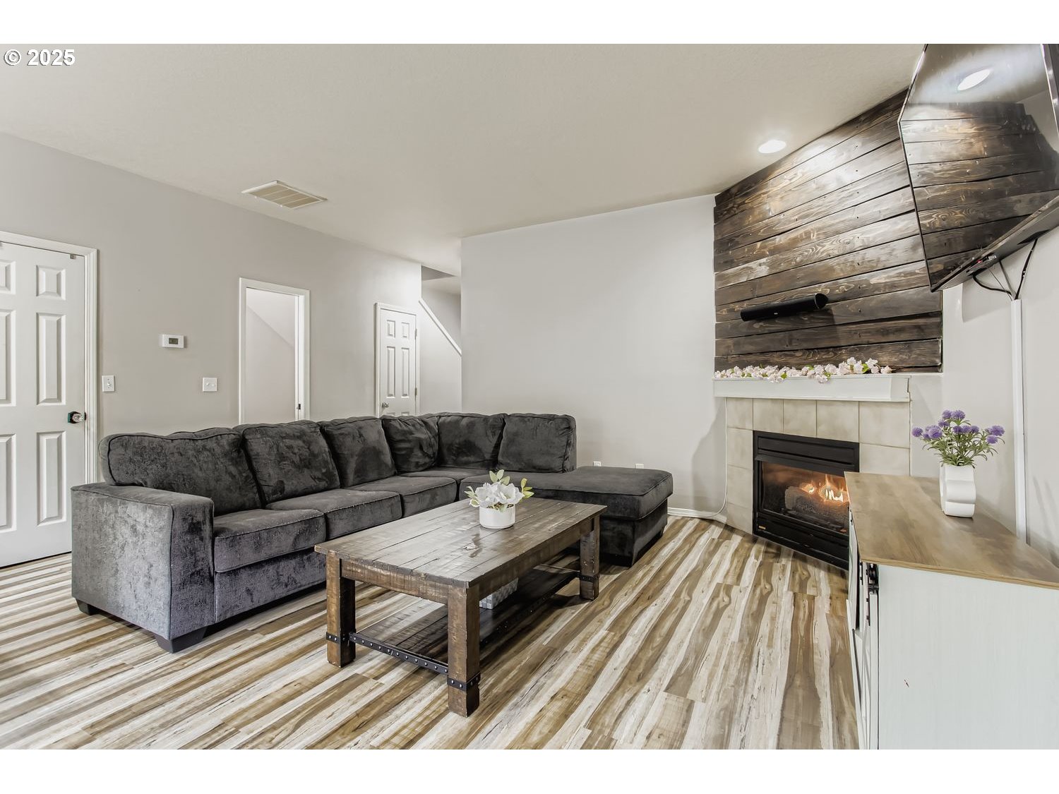 3138 Southwest 177th Place Beaverton, OR 97003 - Photo 6 of 28 a living room with furniture a flat screen tv and a fireplace