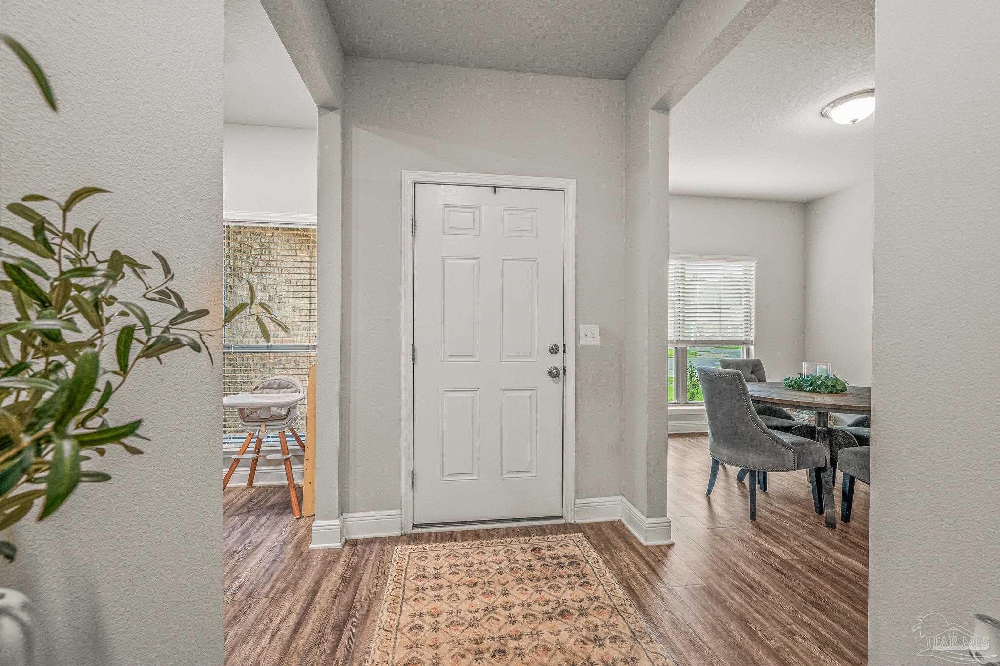5329 Talon Road Pace, FL 32571 - Photo 17 of 45 a view of a hallway with wooden floor and a dining room