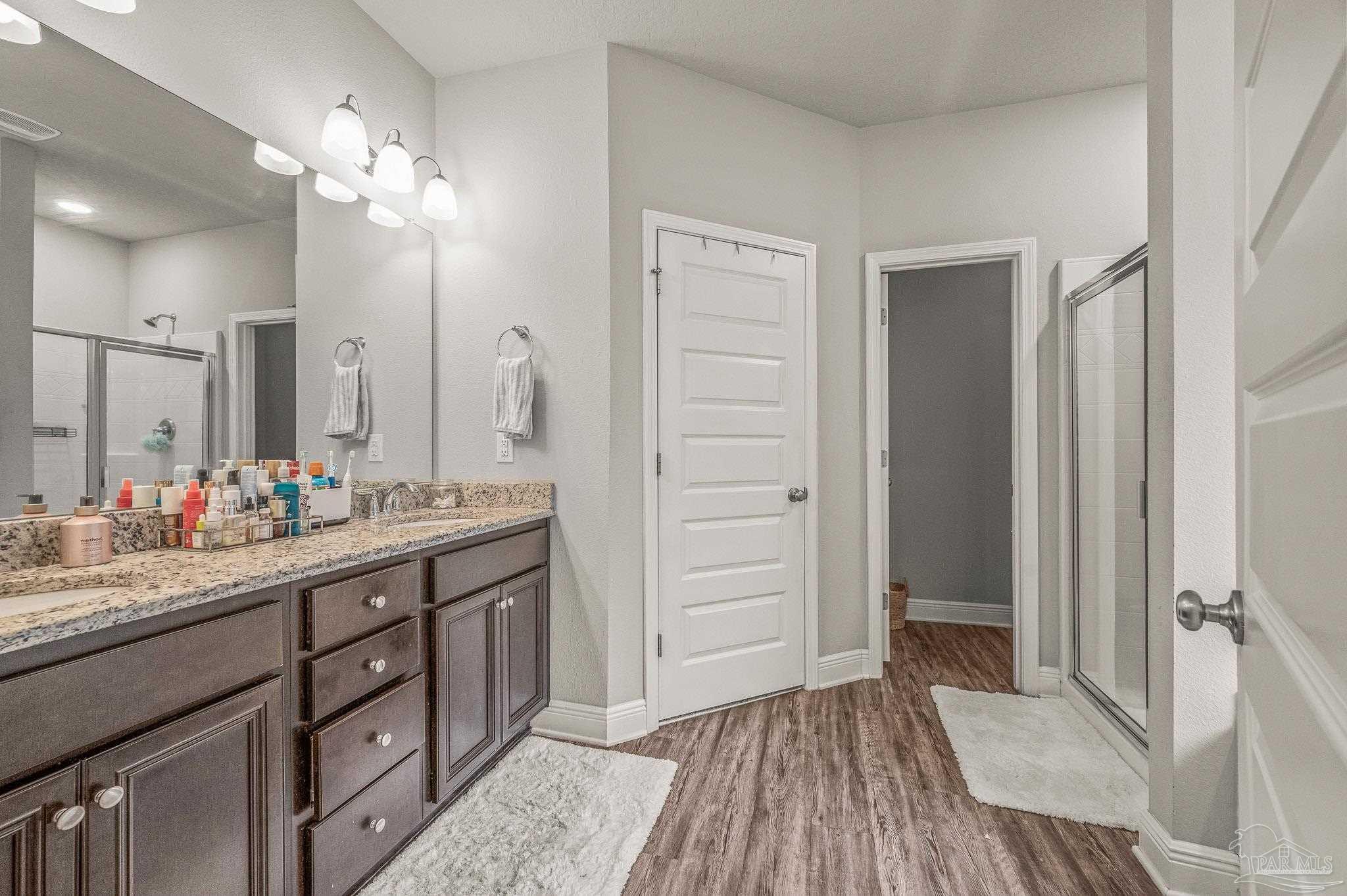 5329 Talon Road Pace, FL 32571 - Photo 29 of 45 a bathroom with a double vanity sink a mirror and a shower