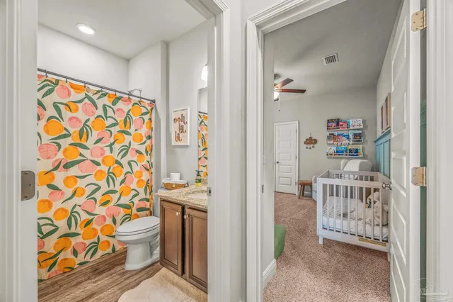 a bathroom with a granite countertop sink a toilet and a mirror
