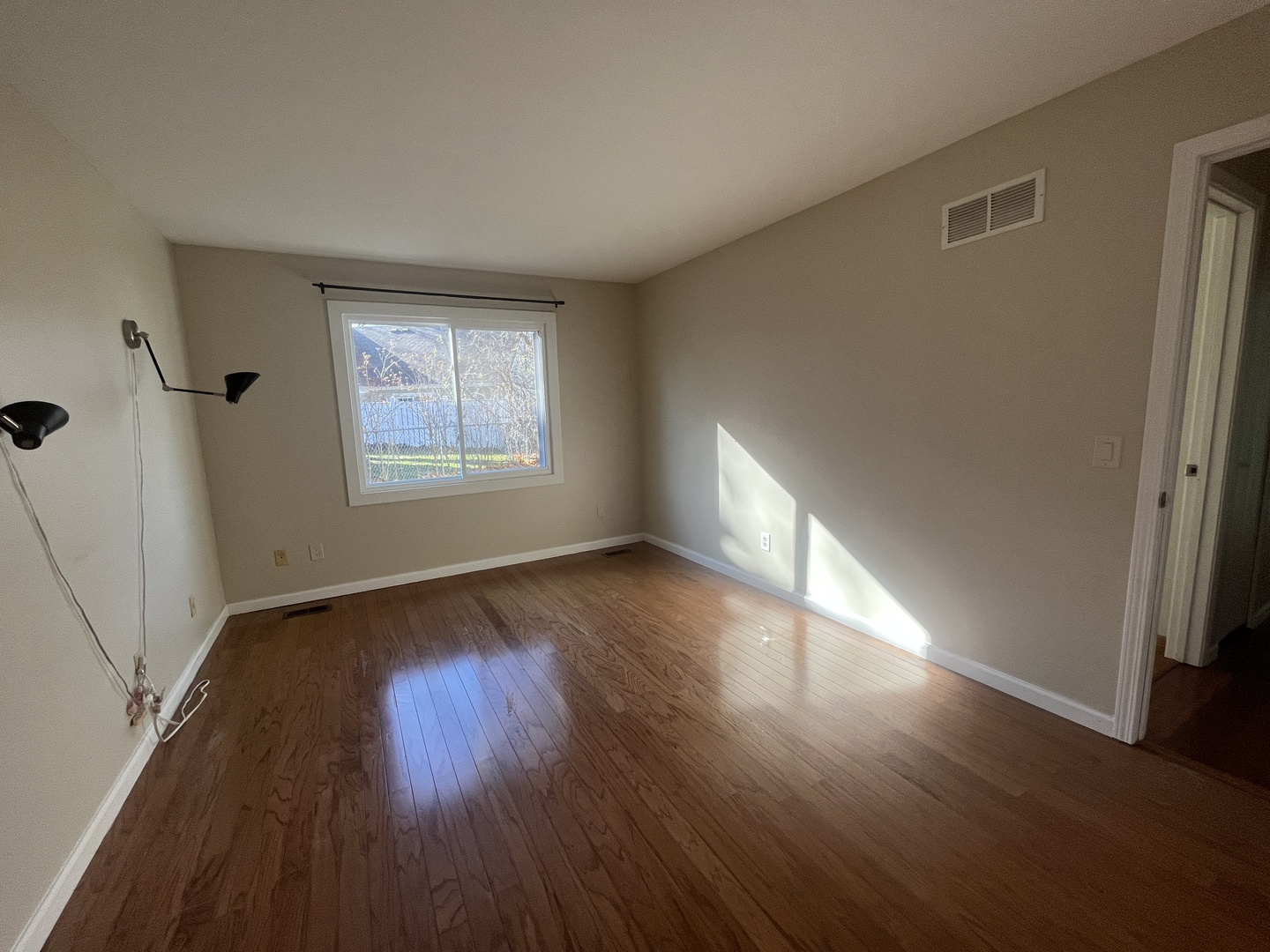1748 Brookdale Road Naperville, IL 60563 - Photo 21 of 28 a view of an empty room with wooden floor and a window