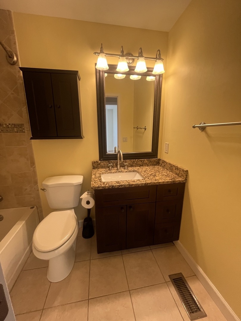 1748 Brookdale Road Naperville, IL 60563 - Photo 26 of 28 a bathroom with a toilet and a mirror