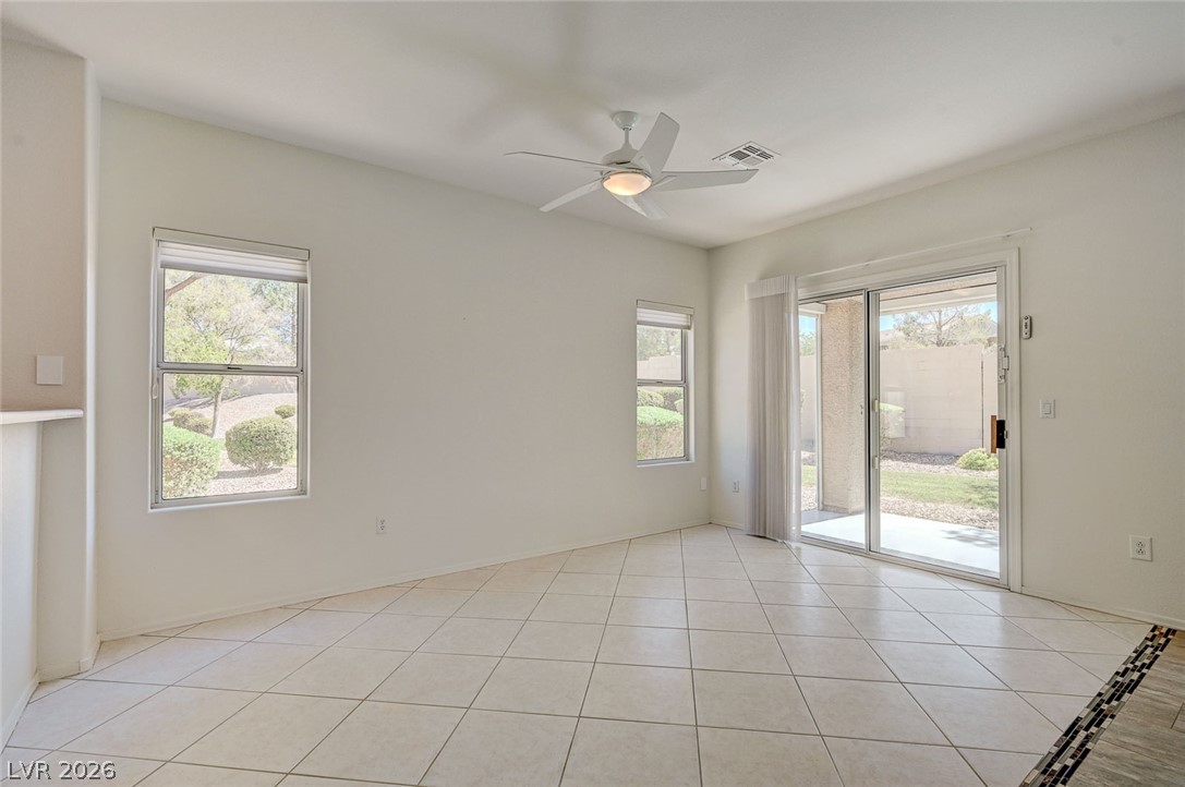 2529 Springville Way Henderson, NV 89052 - Photo 12 of 70 Sliding glass doors open to the backyard from this tile-floored living area.