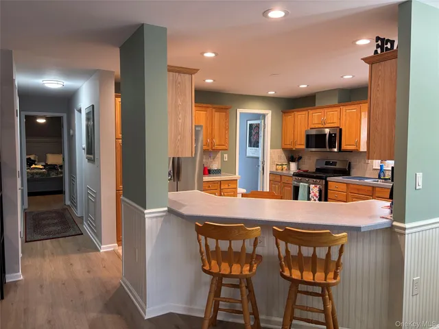 a dining room with wooden floor a chandelier a wooden table and chairs