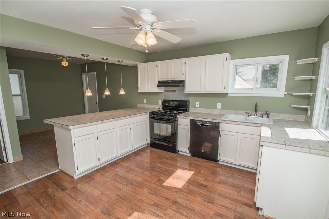 1095 Lander Road Cleveland, OH 44143 - Photo 6 of 29 Updated Kitchen with Laminated Wood Floor, Pendant Lights over Breakfast Bar, Tile Counters and More!
