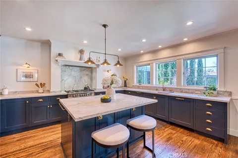 a kitchen with granite countertop kitchen island a stove a table and chairs in it