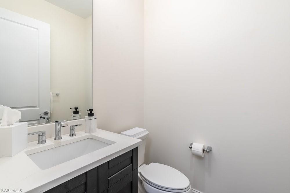 16394 Corsica Way, Unit 101 Naples, FL 34110 - Photo 11 of 43 a bathroom with a sink a toilet and mirror