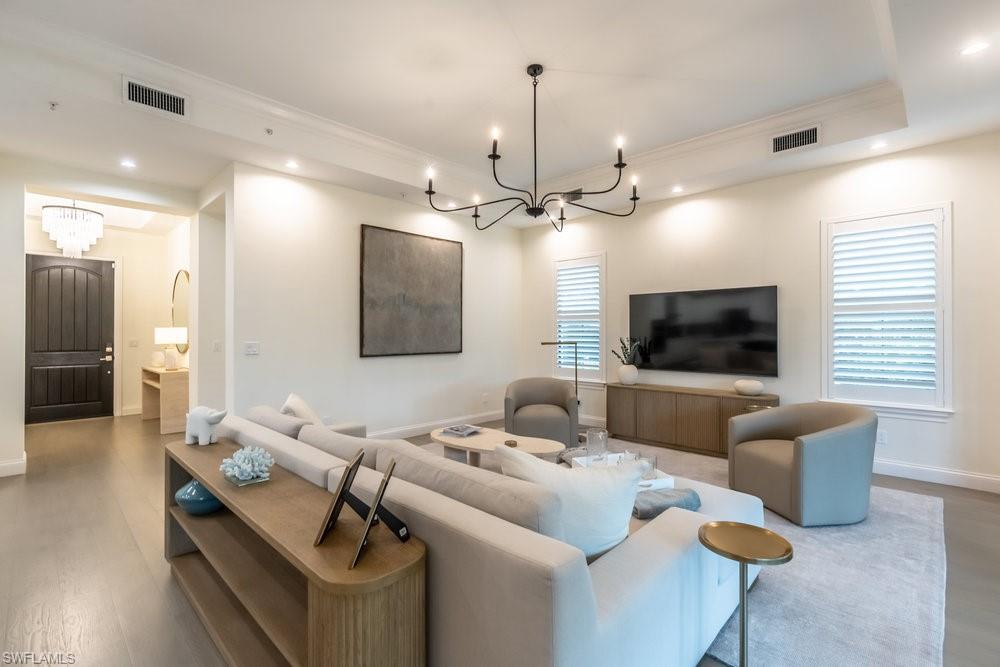 16394 Corsica Way, Unit 101 Naples, FL 34110 - Photo 12 of 43 a living room with furniture and a flat screen tv