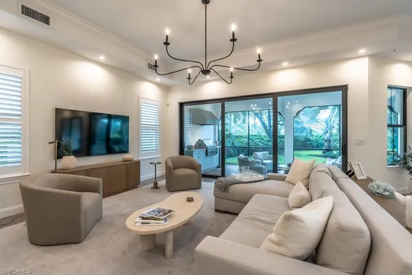 a living room with furniture a ceiling fan and a large window