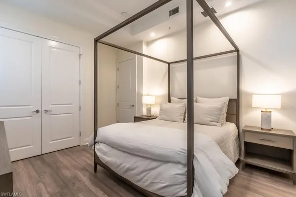 a bedroom with a large bed and a chandelier