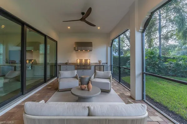 a living room with patio furniture and a garden