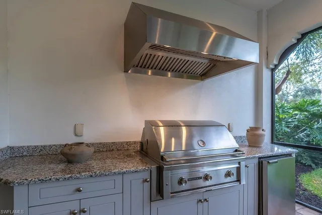 a kitchen with a stove a sink and cabinets