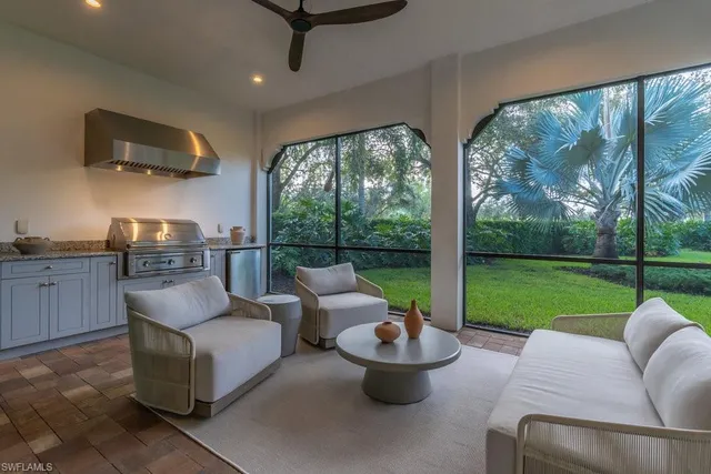 a living room with patio furniture and a garden