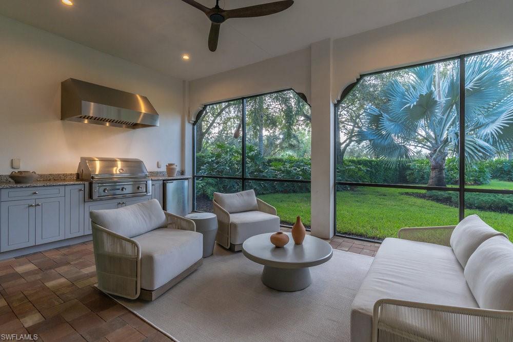 16394 Corsica Way, Unit 101 Naples, FL 34110 - Photo 31 of 43 a living room with patio furniture and a garden