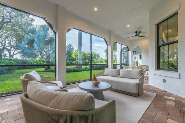 a living room with patio furniture and a garden