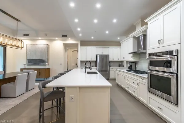 a kitchen with refrigerator and chairs