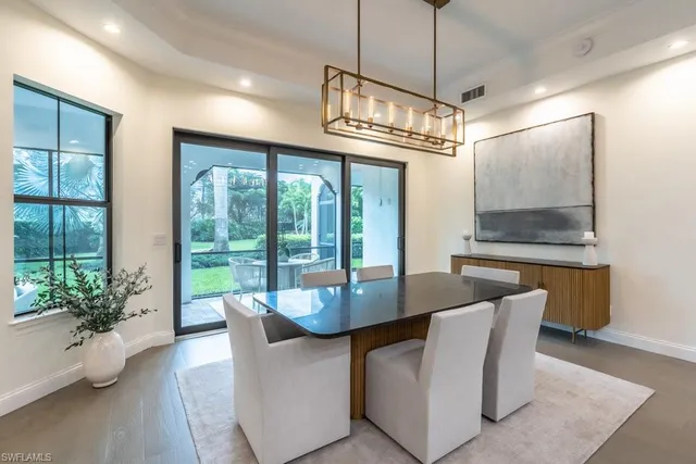 a dining room with furniture wooden floor and a chandelier