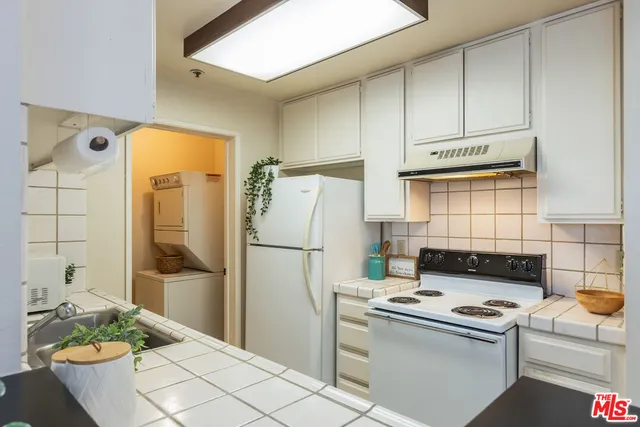 a kitchen with a refrigerator a stove a washer and dryer