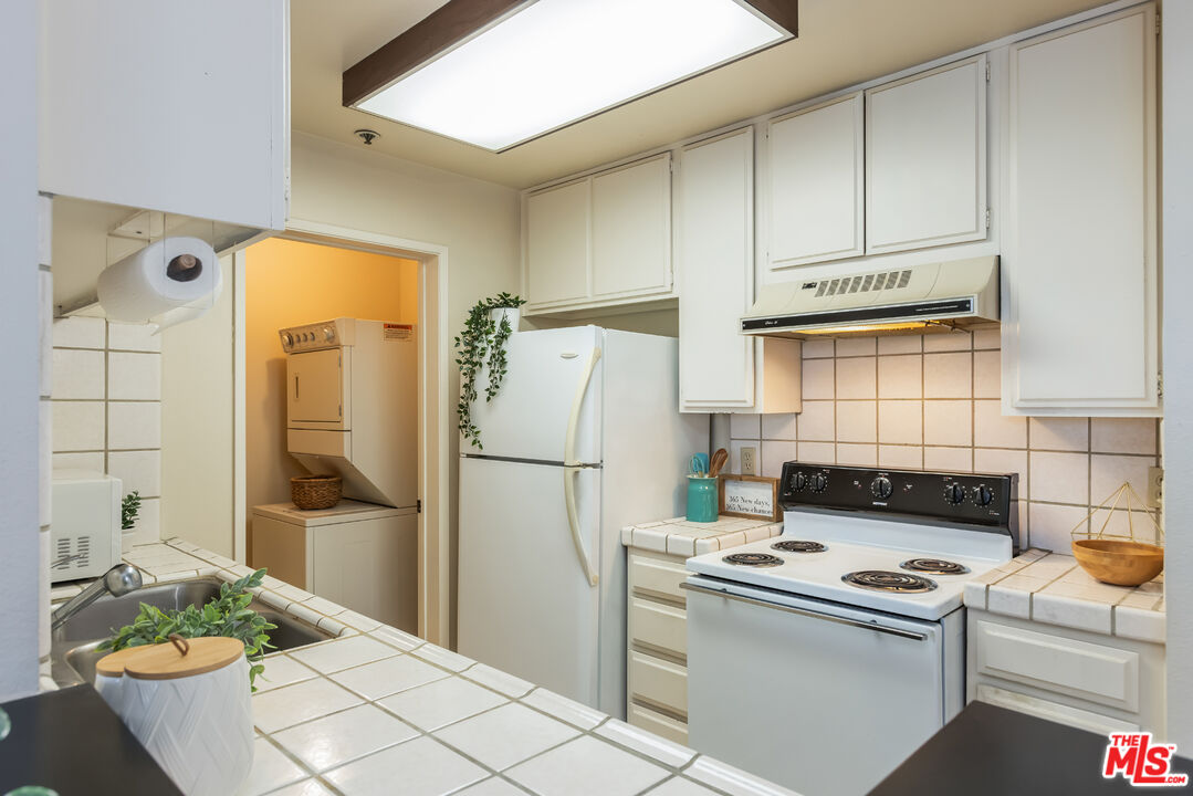 222 South Central Avenue, Unit 315 Los Angeles, CA 90012 - Photo 9 of 22 a kitchen with a refrigerator a stove a washer and dryer