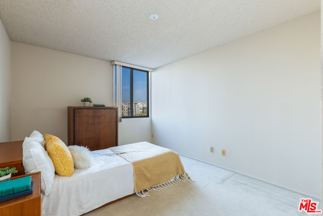 222 South Central Avenue, Unit 315 Los Angeles, CA 90012 - Photo 10 of 22 a bedroom with a bed and chair