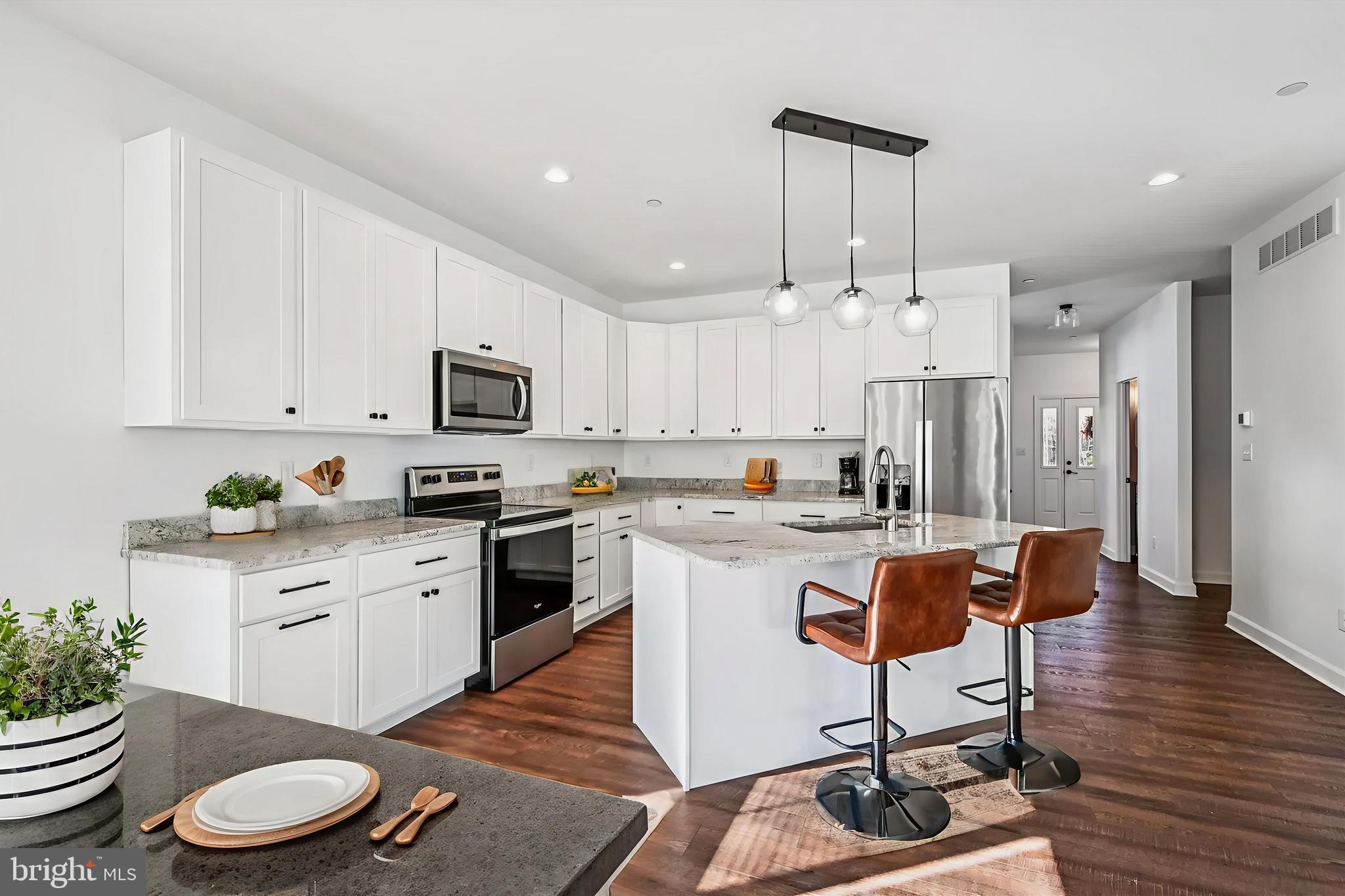 a kitchen with a sink a stove a refrigerator and white cabinets