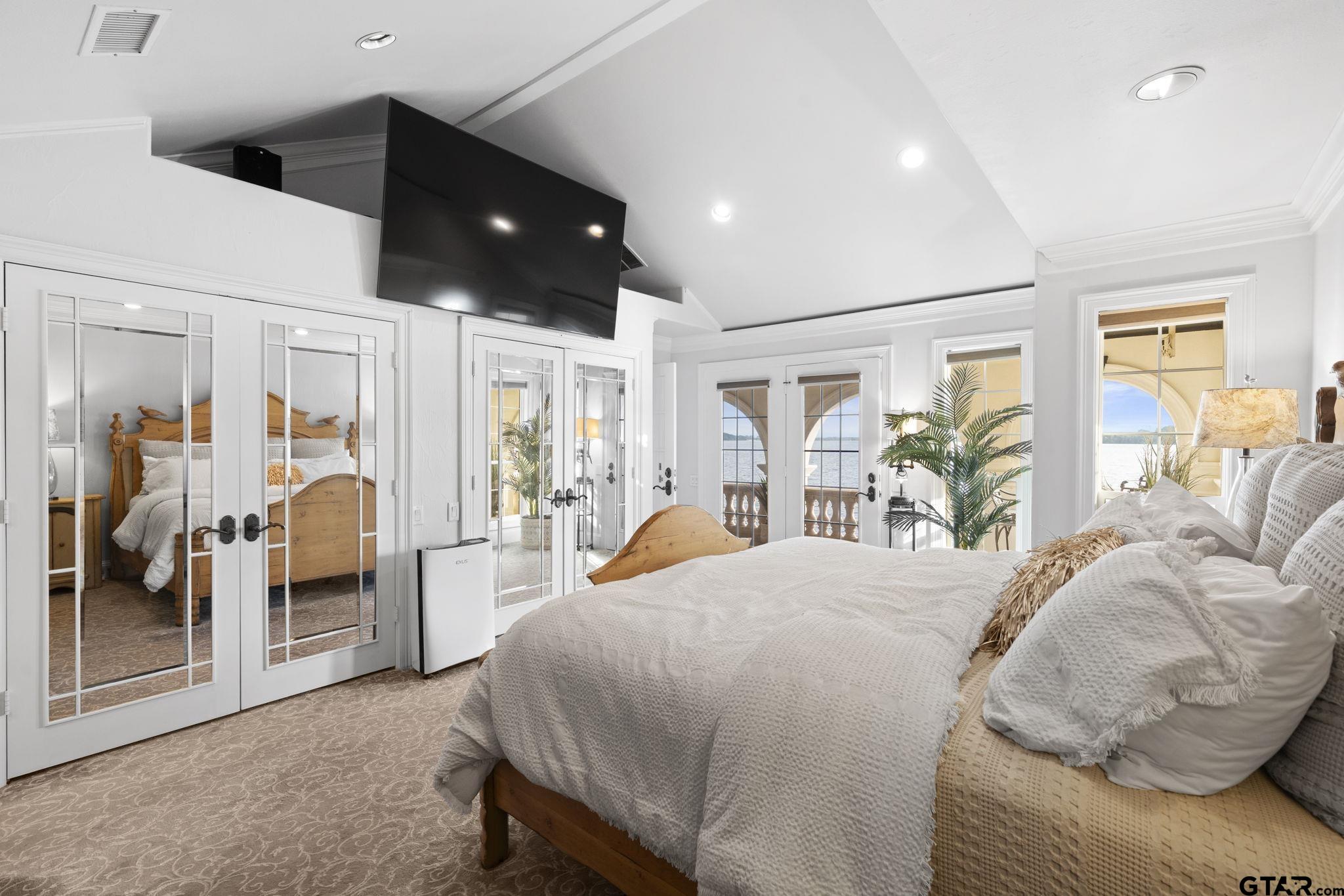 15996 Eastside Road Tyler, TX 75707 - Photo 24 of 48 a bedroom with a large bed and a chandelier