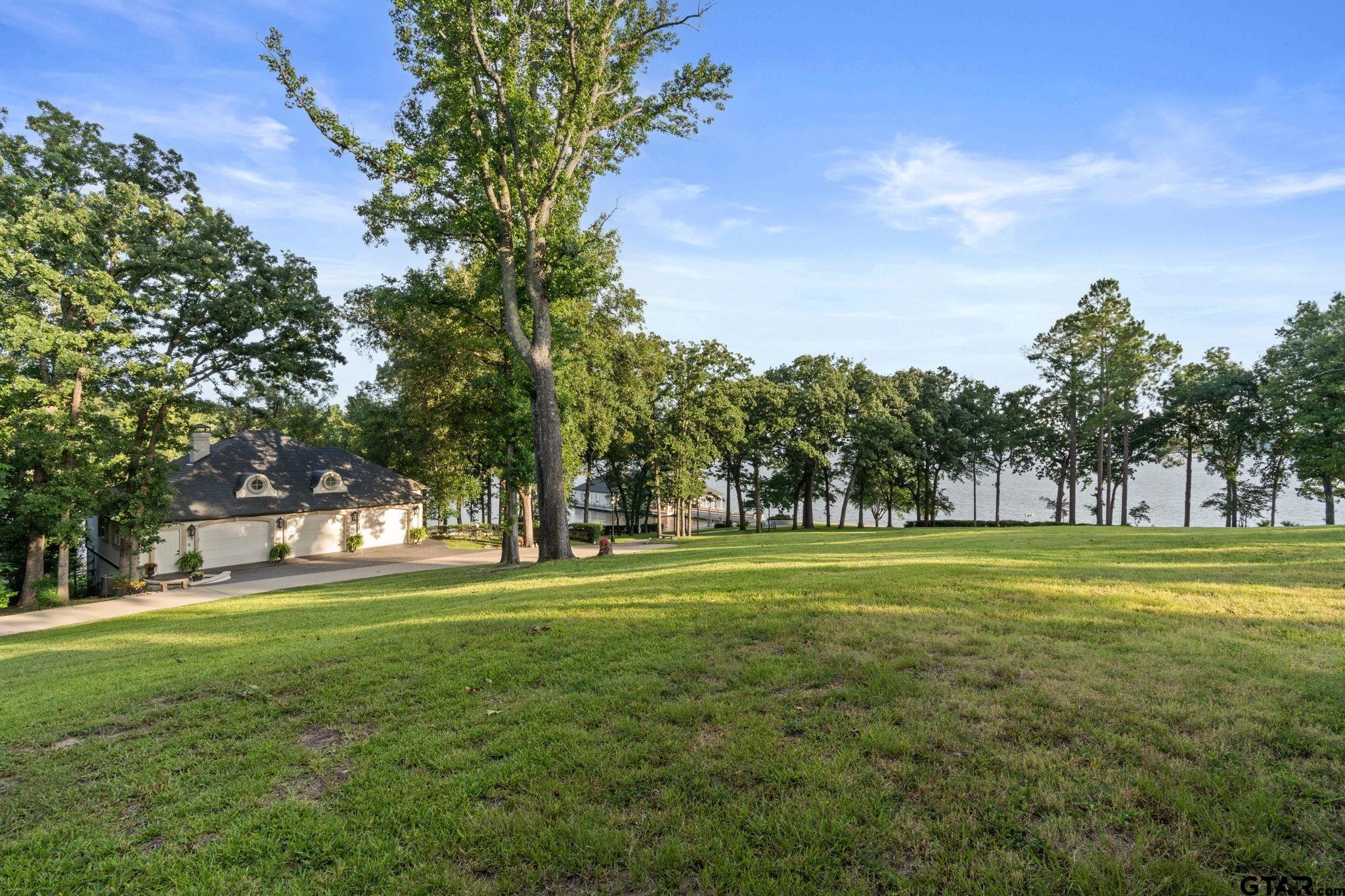 15996 Eastside Road Tyler, TX 75707 - Photo 39 of 48 a big yard with lots of trees in the background
